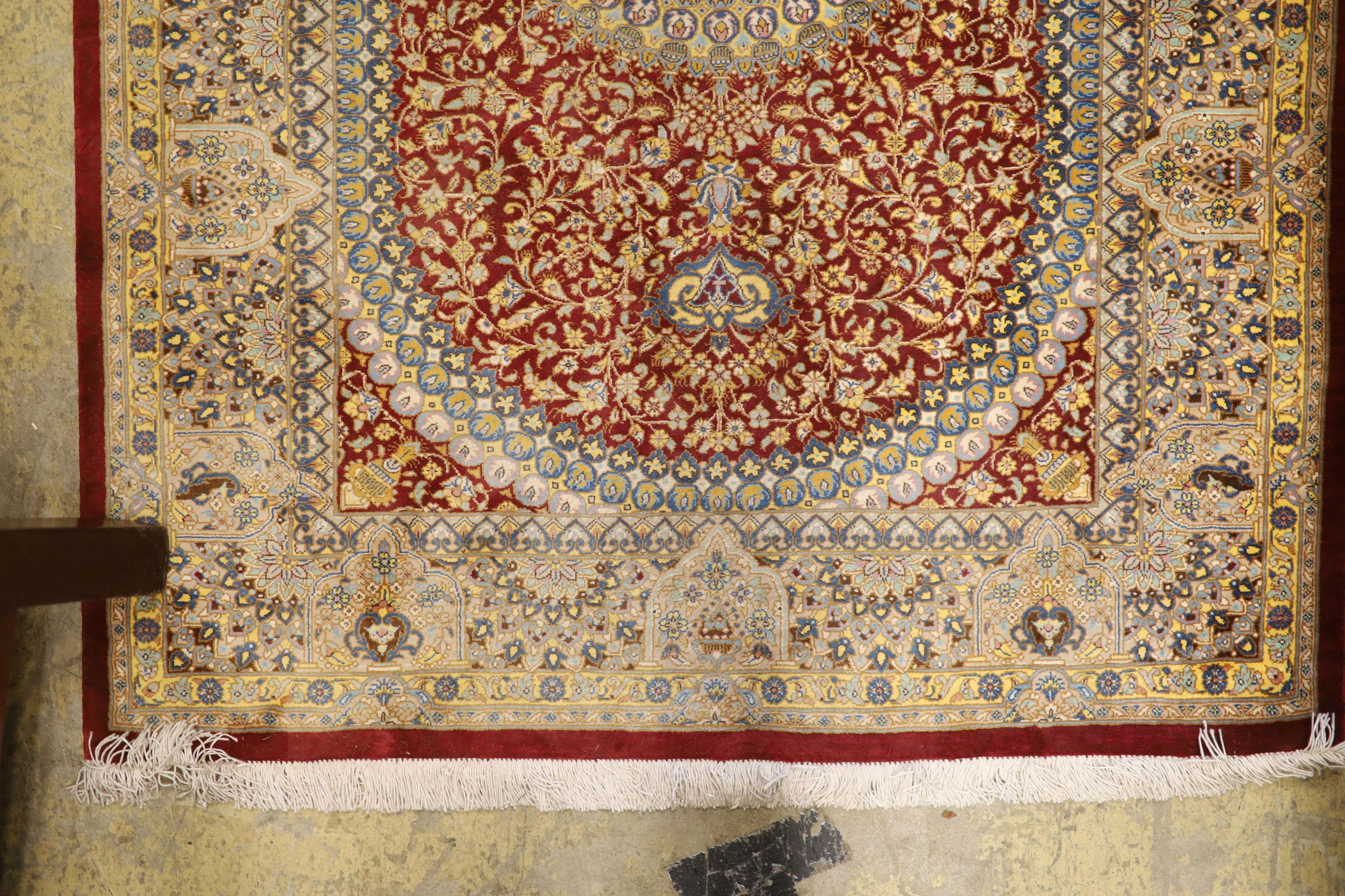 A Persian part red ground silk multi-floral patterned rug, 110 x 80cm